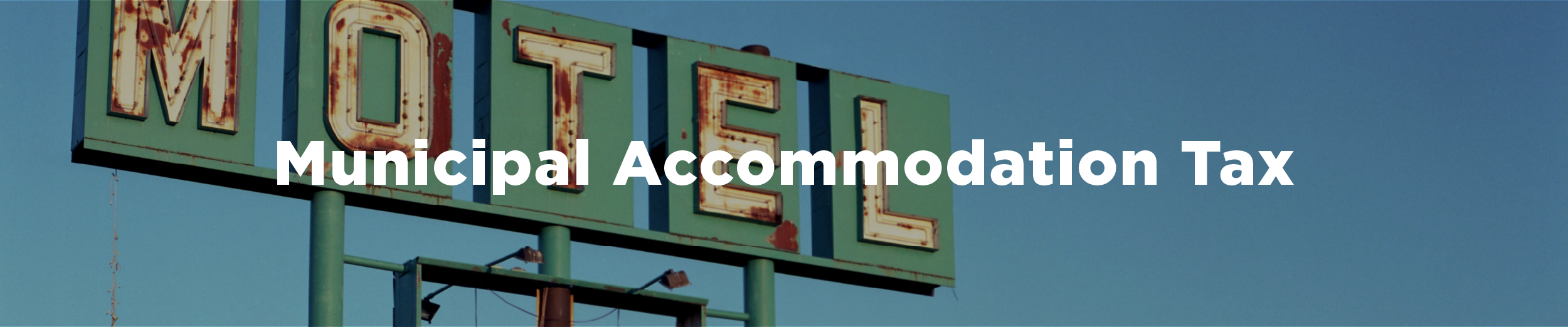 A weathered highway motel sign with the overlaid text "Municipal Accommodation Tax"