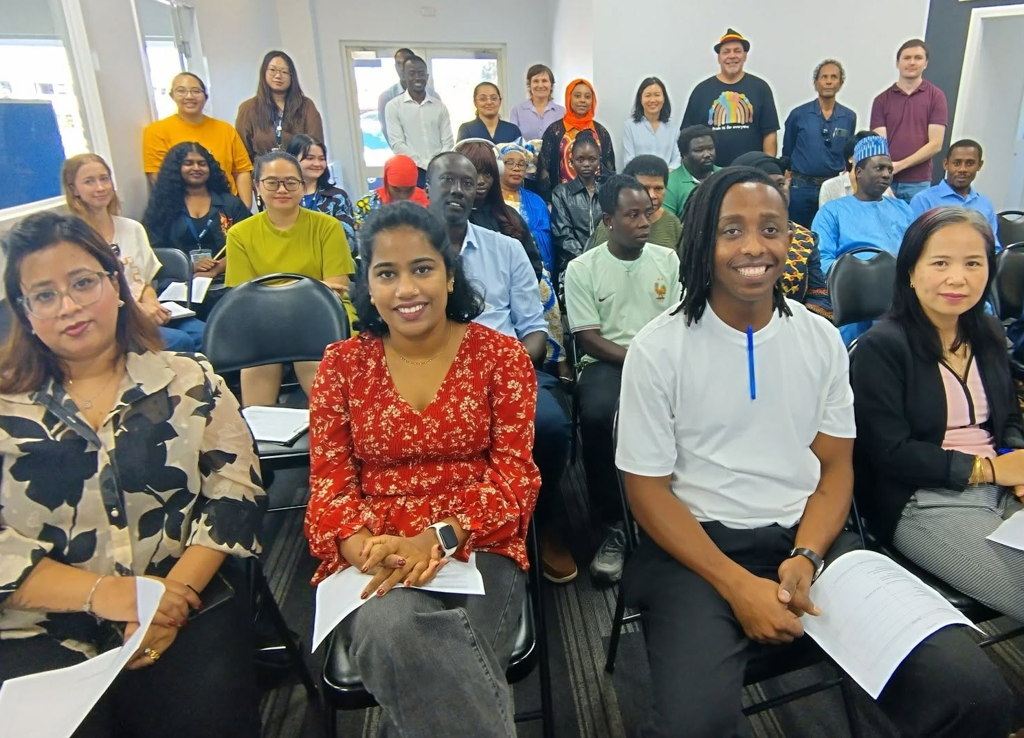 Townsville Multicultural Support Group employees and clients sit, smiling