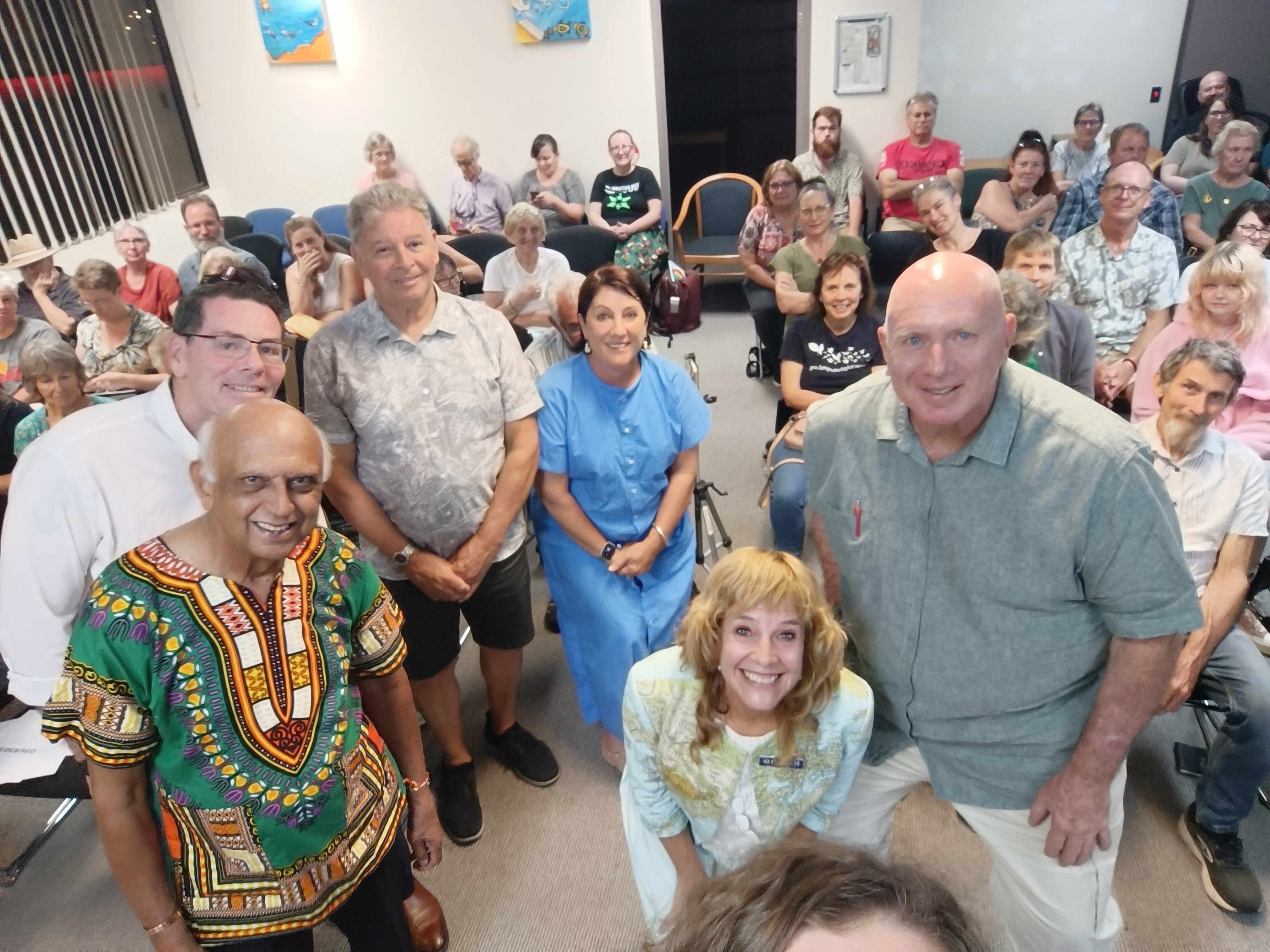 Candidates smile in front of an audience