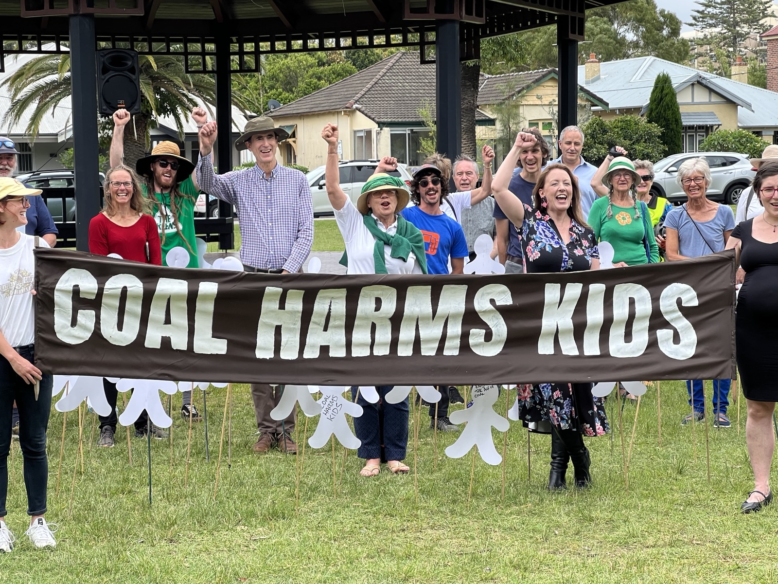 Abigail standing with people behind a banner that reads "coal harms kids"