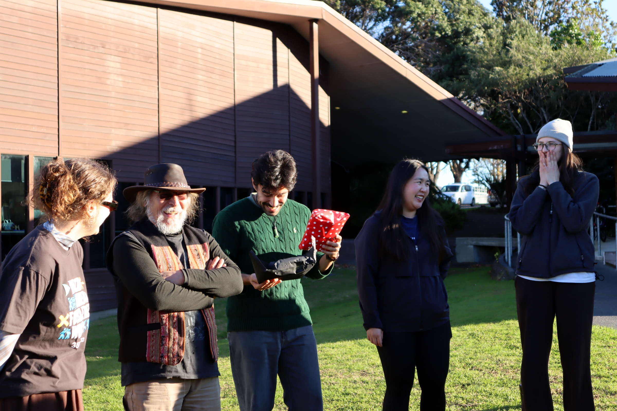 OraTaiao members playing pass the parcel in the sun outside