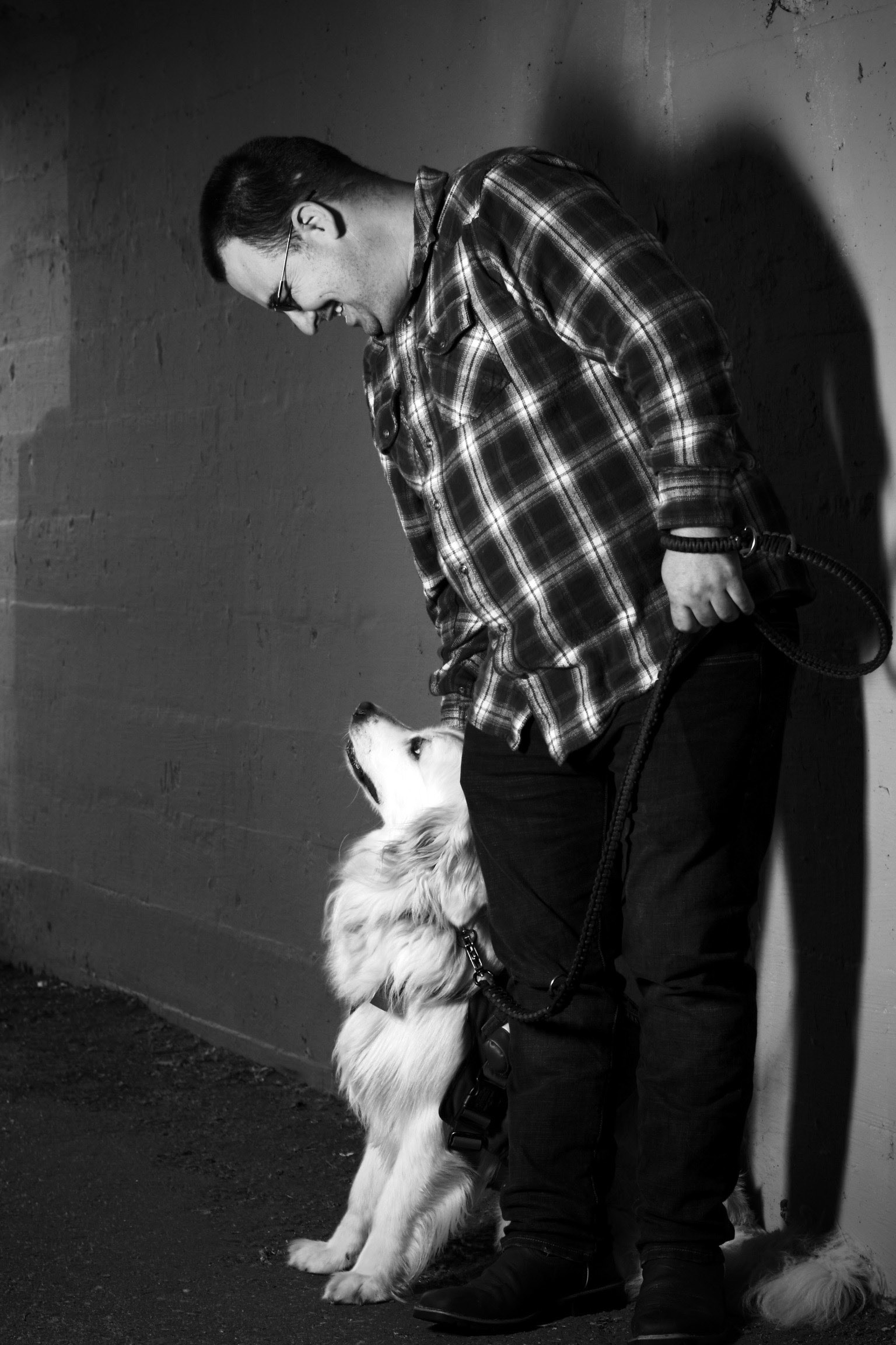 B&W pro photo of vet with service dog, smiling