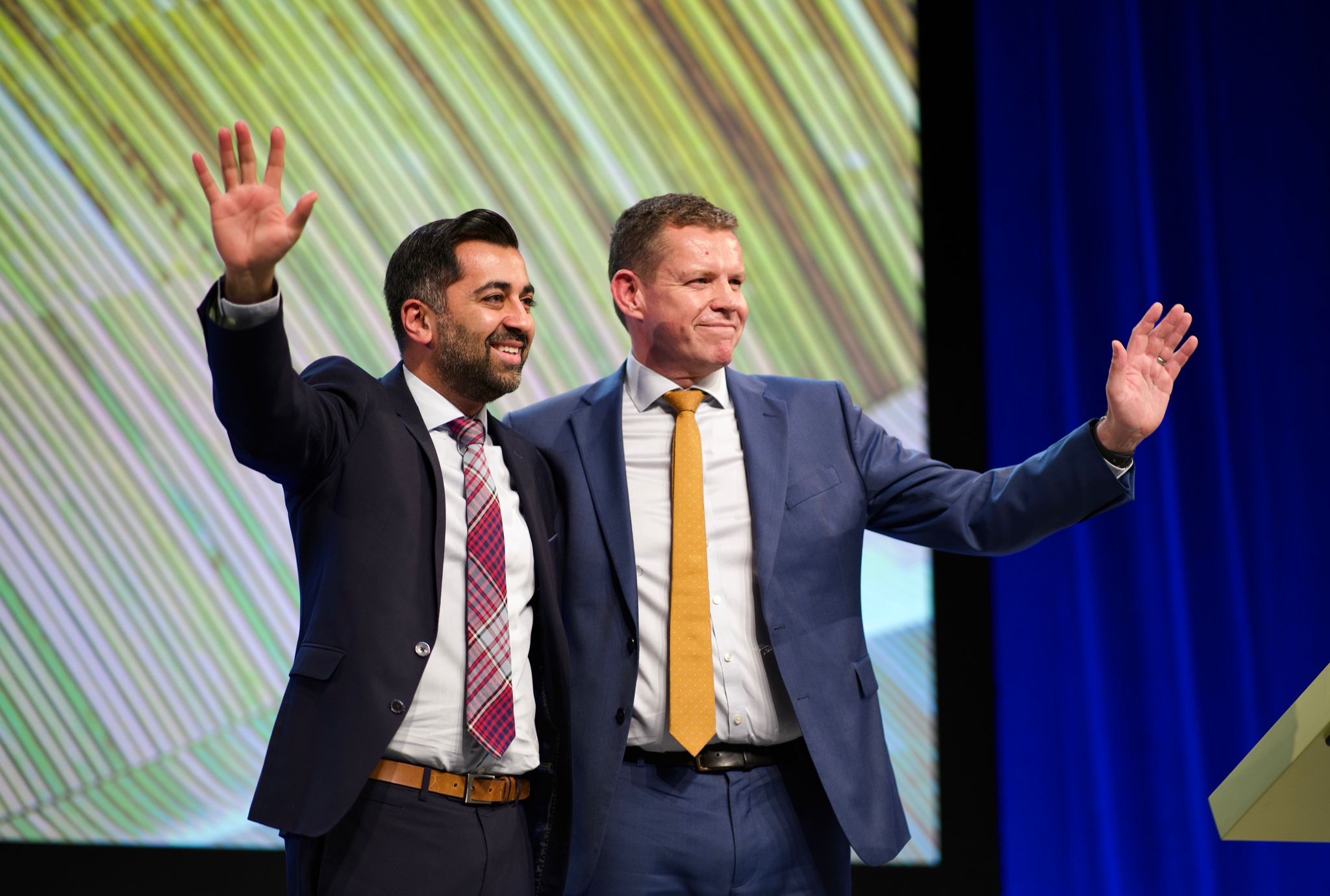 Humza Yousaf a Rhun ap Iorwerth ar y llwyfan yn y gynhadledd SNP