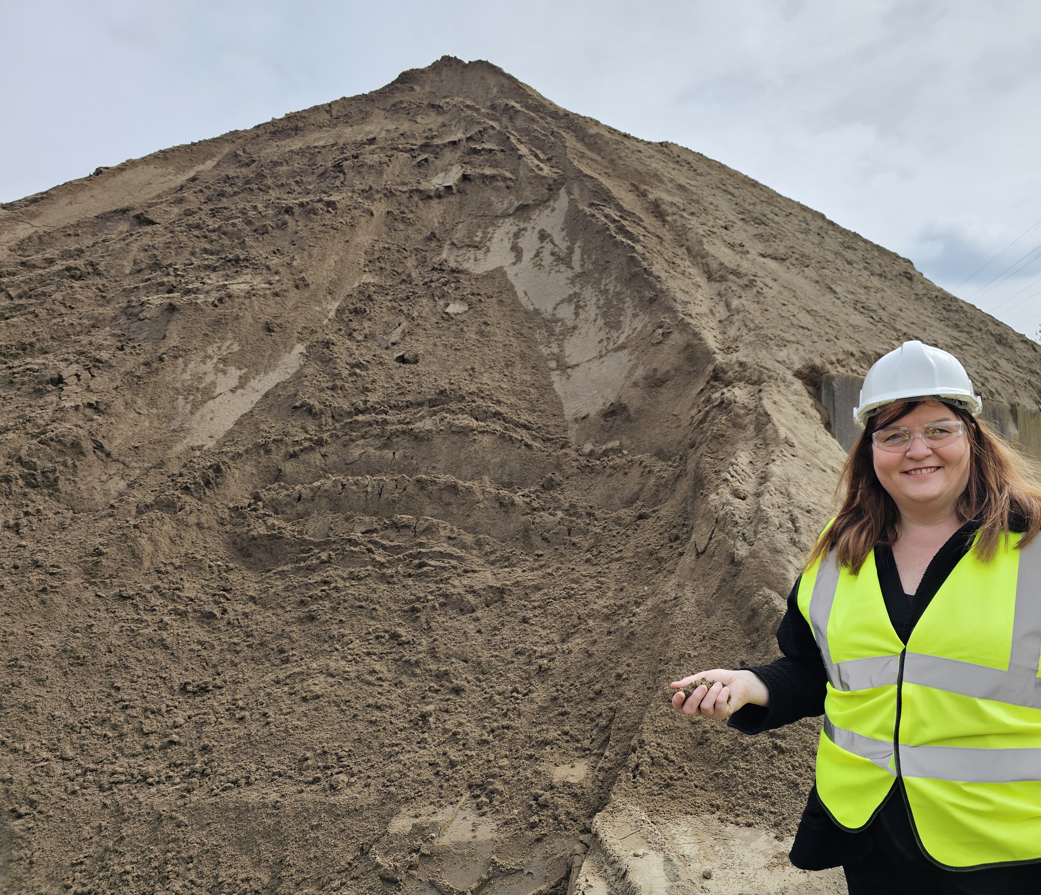 Sioned next to a large pile of sand