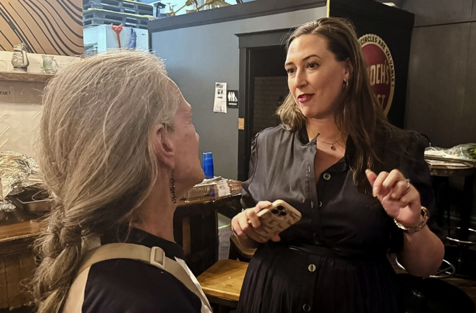 Democrat Catelin Drey talks to a supporter at a victory party at Jackson Street Brewing in Sioux City