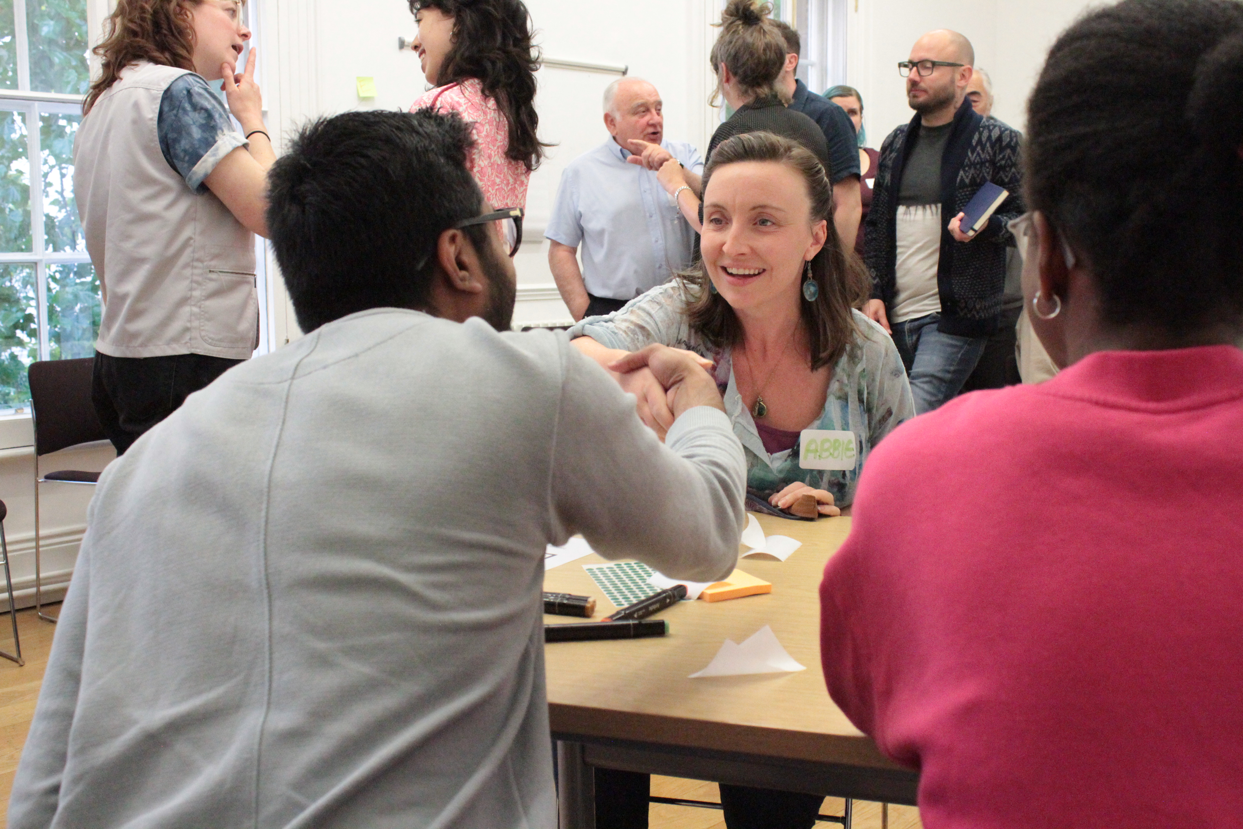 A woman and a man shake hands over a table