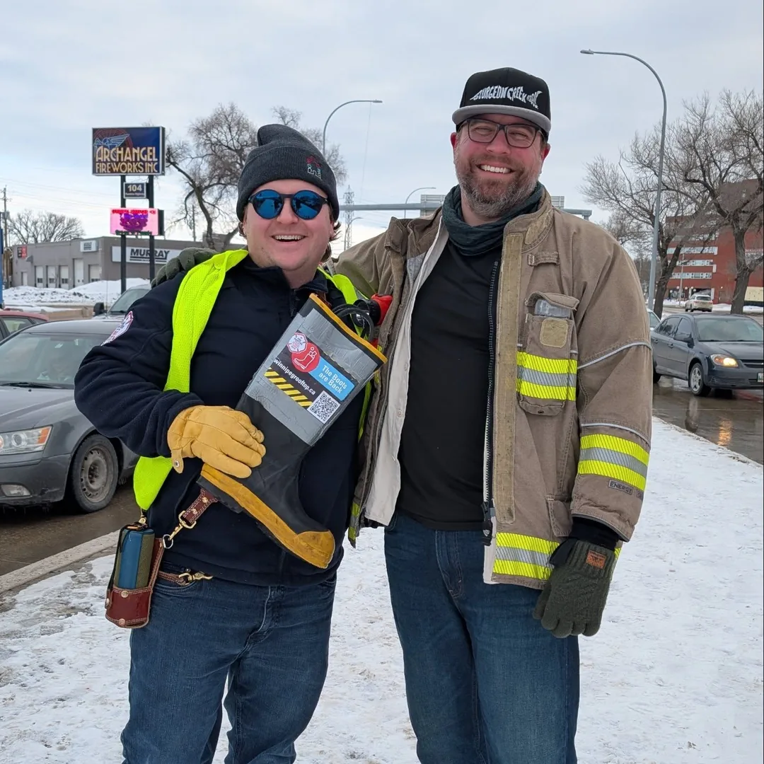 Tyler Crichton standing with a firefighter during a local Boots on the Back campaign