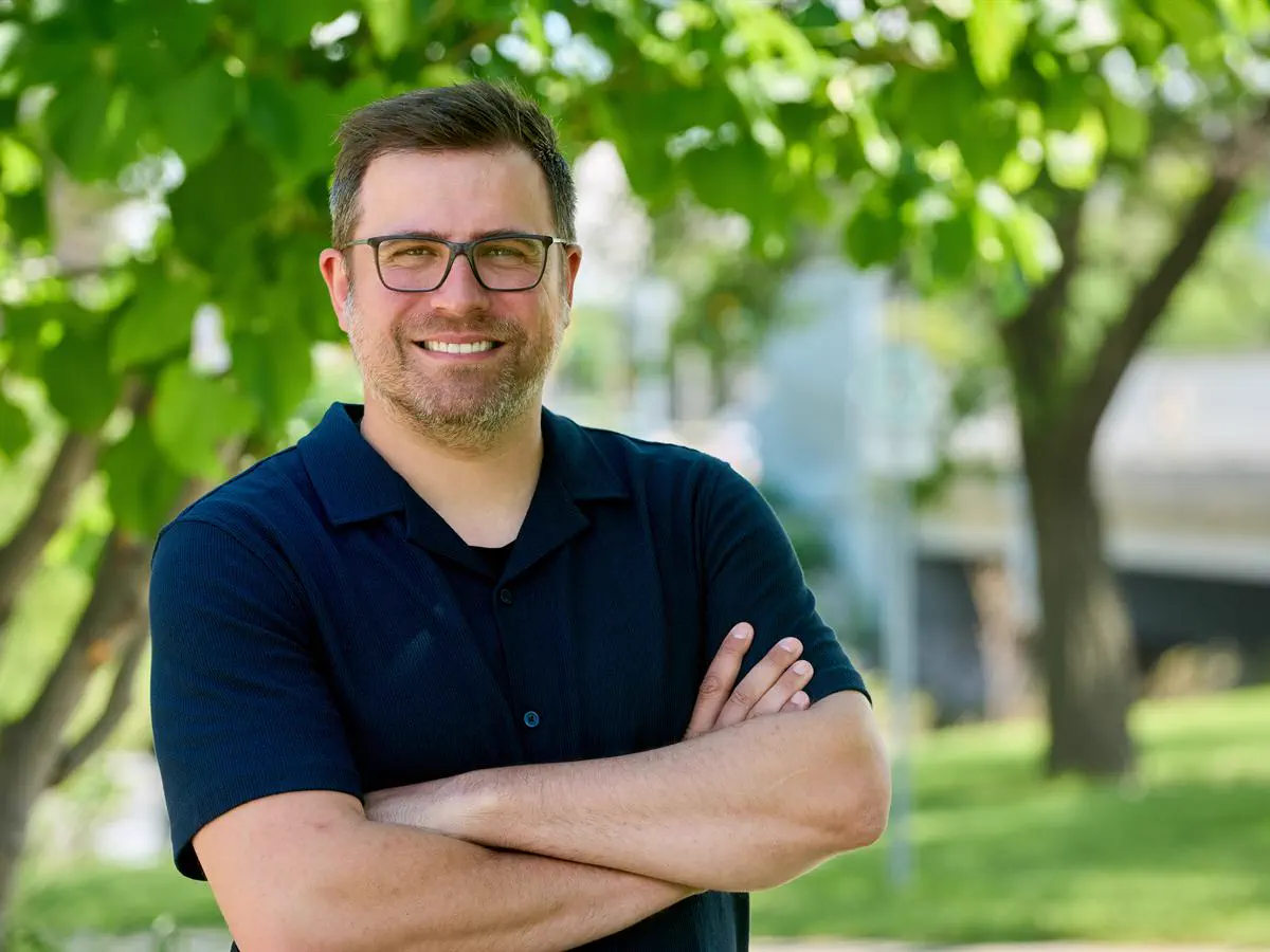 Tyler Crichton smiling under trees in St. James