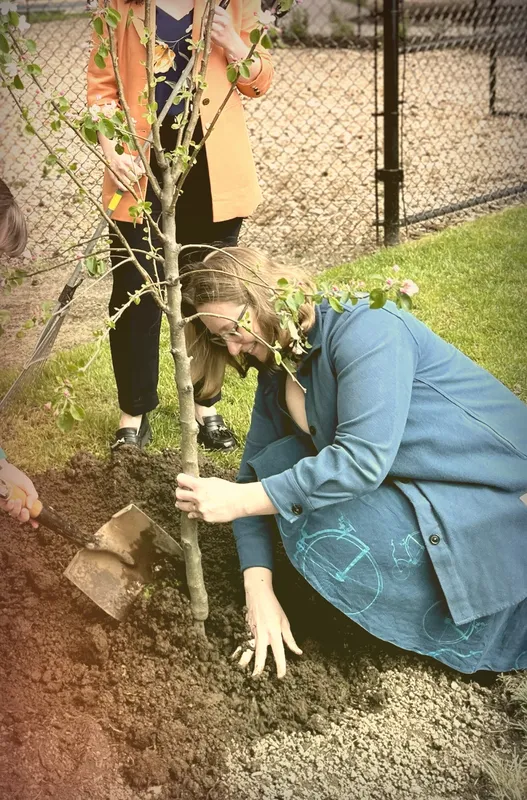 Kimberley Guiry planting a tree with a community member
