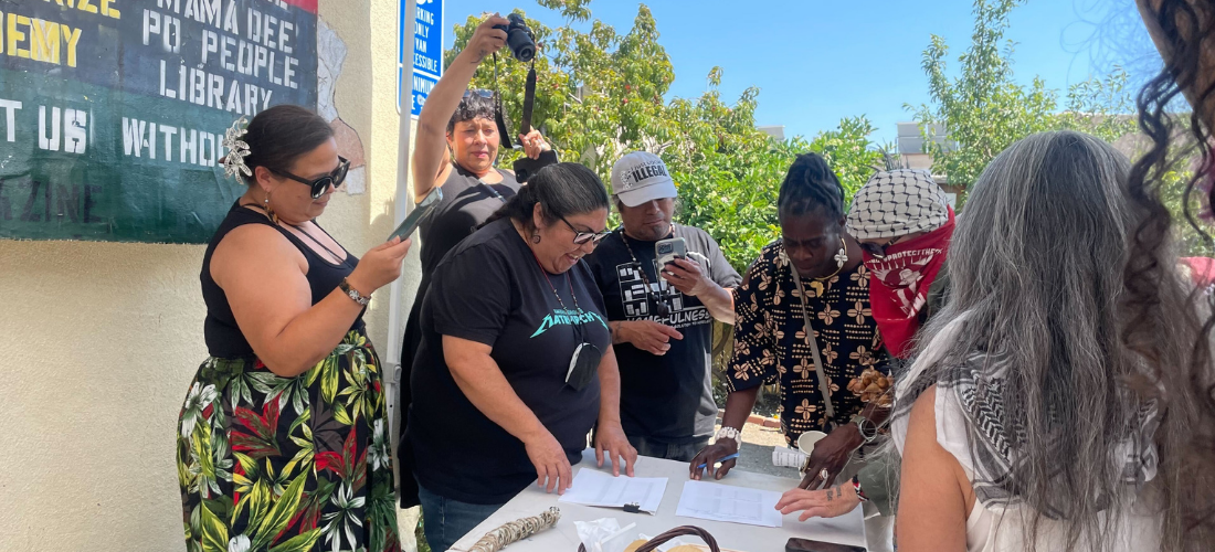 Sogorea Te Land Trust and Homefulness signing a legal document at their liberation easement ceremony