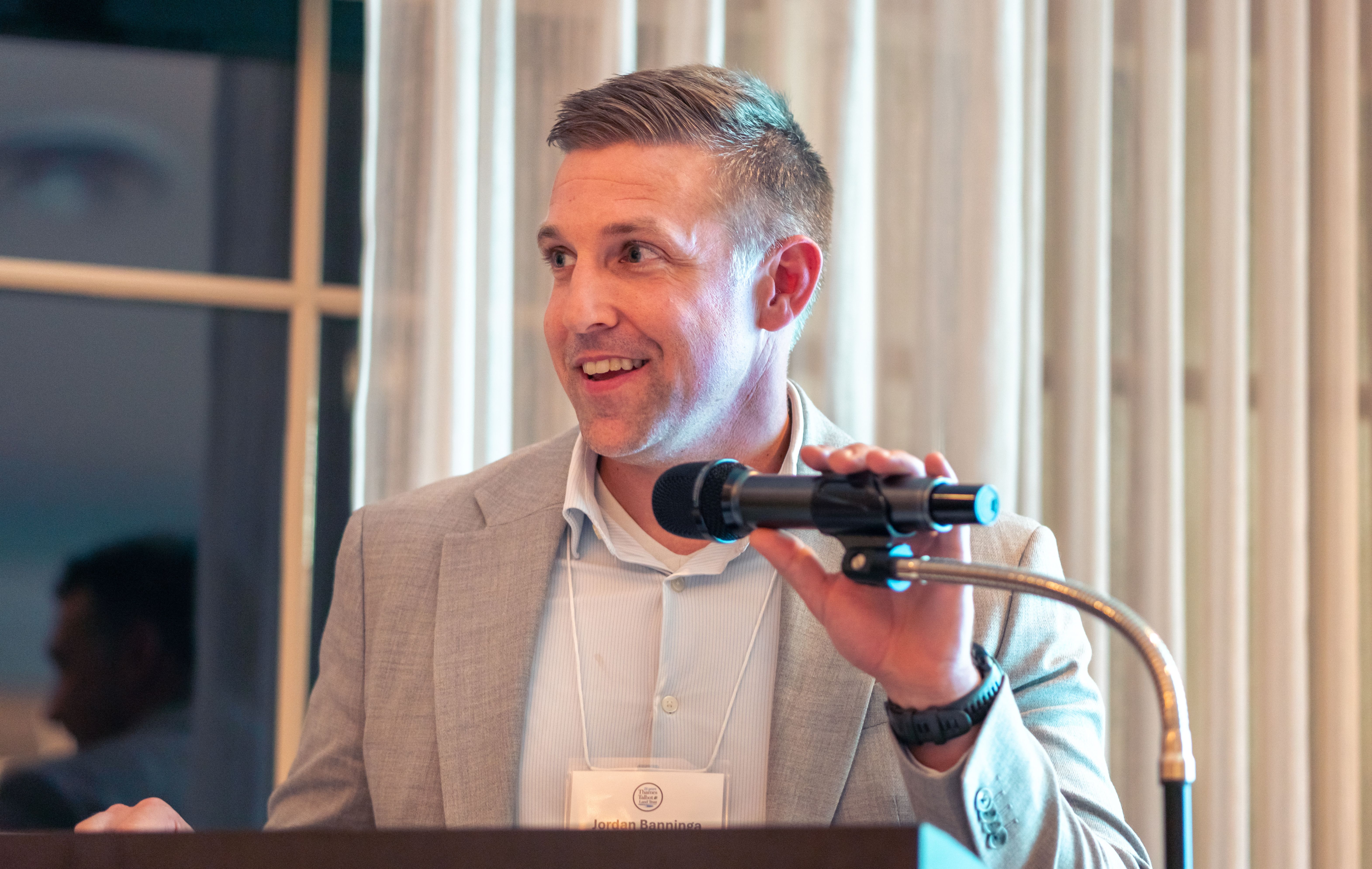 Close up of a middle aged man standing at the microphone and podium