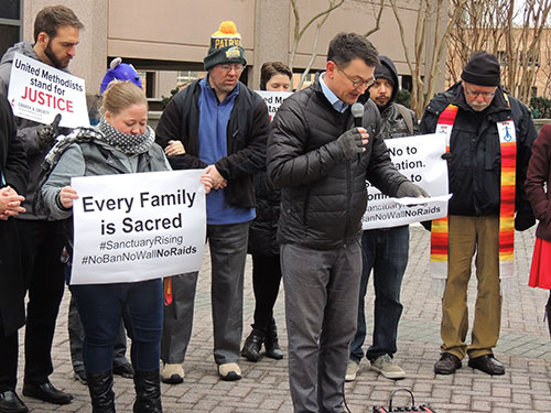 UU pastor Rob Hardies praying, with Jerry Foltz on right in stole