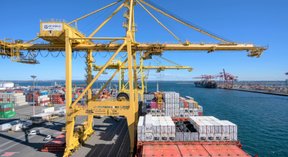 DP World port - a yellow crane moves over containers on a port