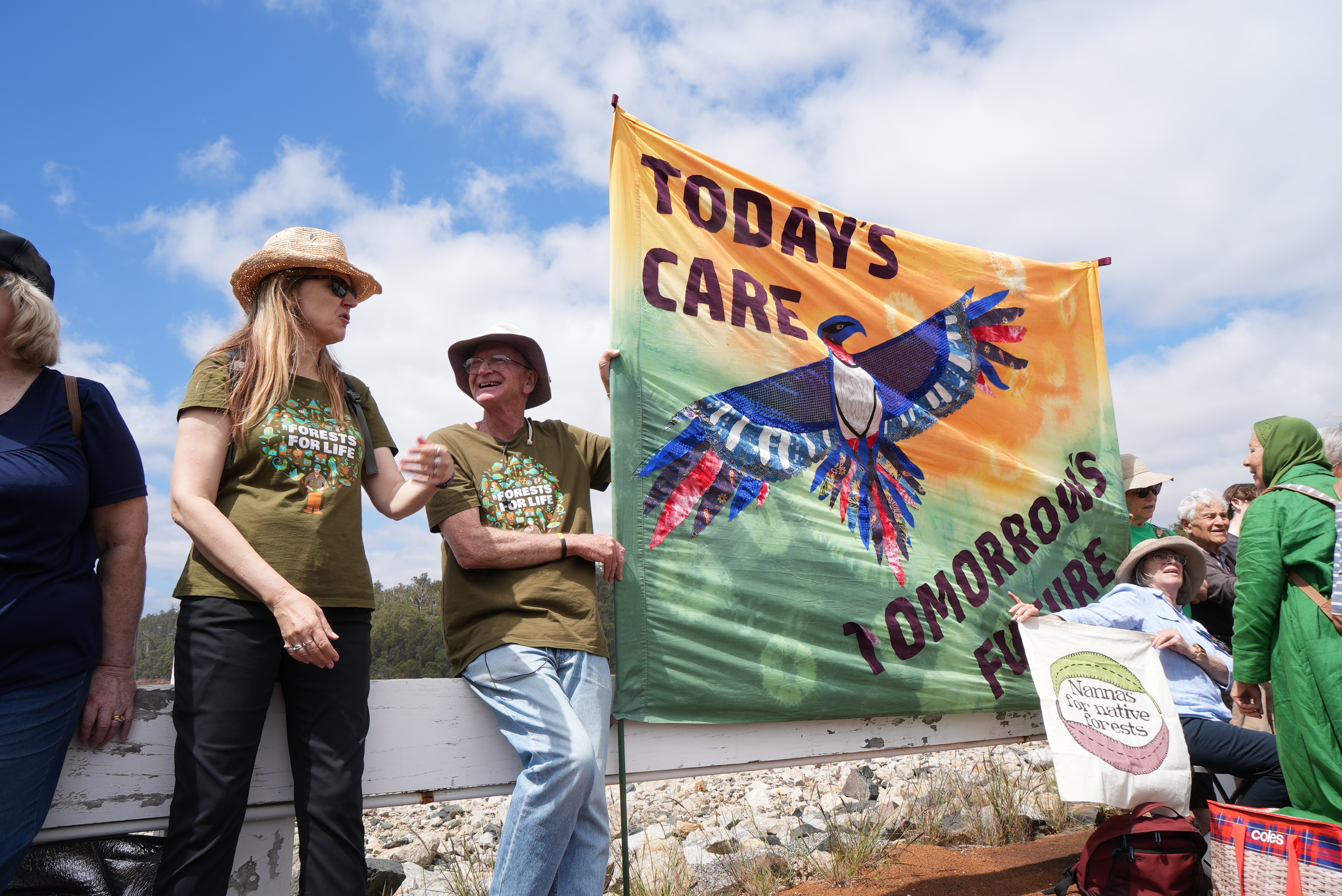 2 people in forests for life shirt smiling at each other, one is holding a banner which reads "today's care, tomorrow's future"